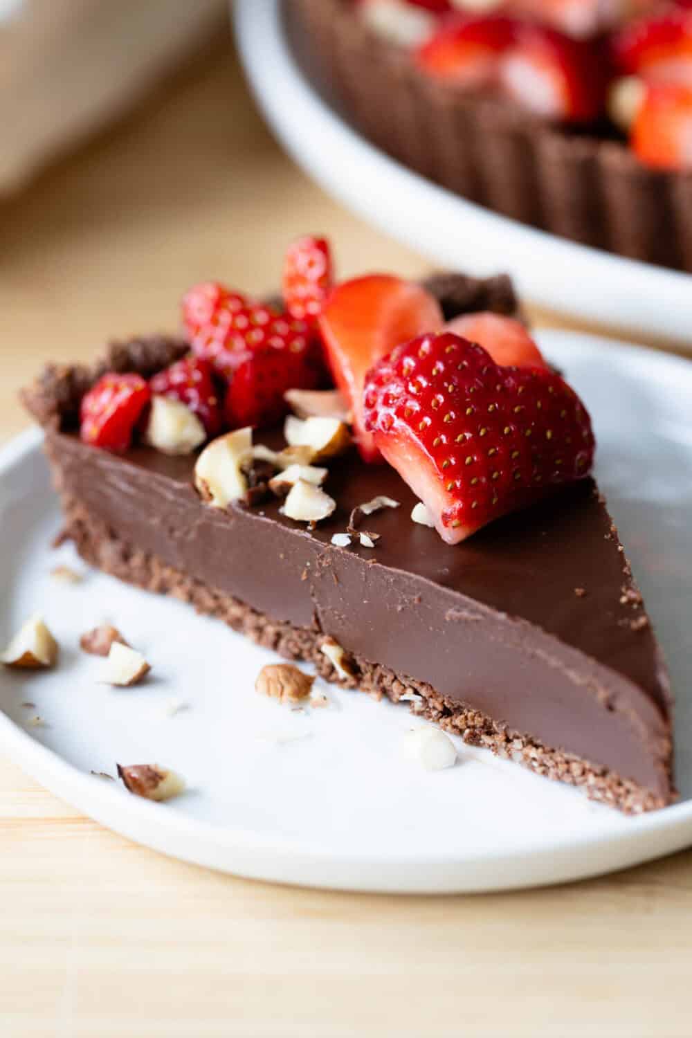 One slice of chocolate tart on a plate to show texture of filling and crust.